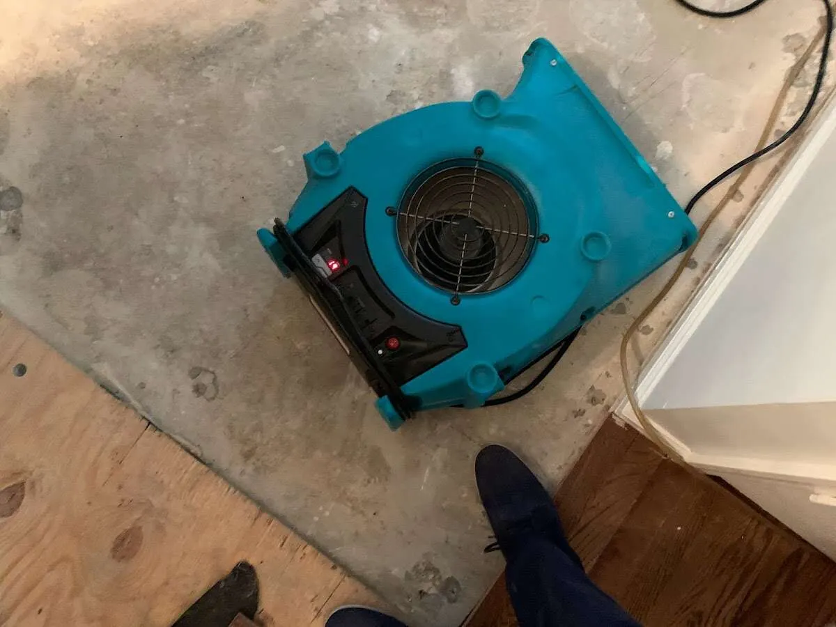 Air mover drying subfloor during Commercial Water Damage Restoration in Hugo